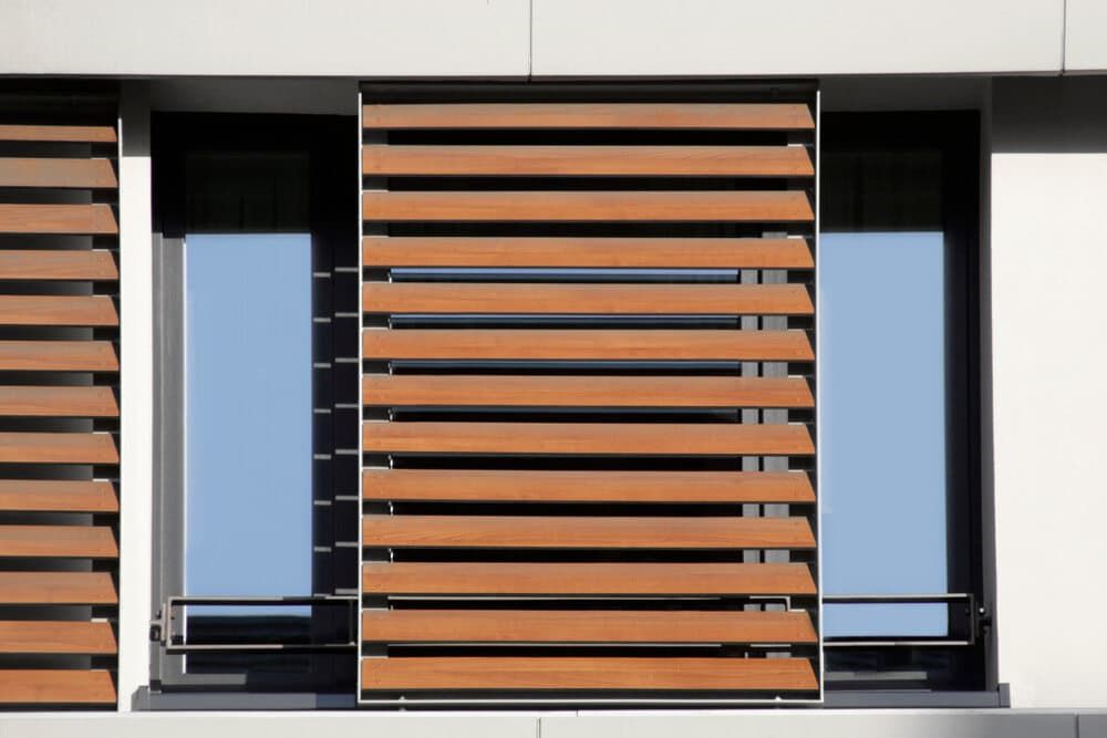 A Window With Wooden Blinds On The Side Of It — Summerland Screens & Awnings In Suffolk Park, NSW