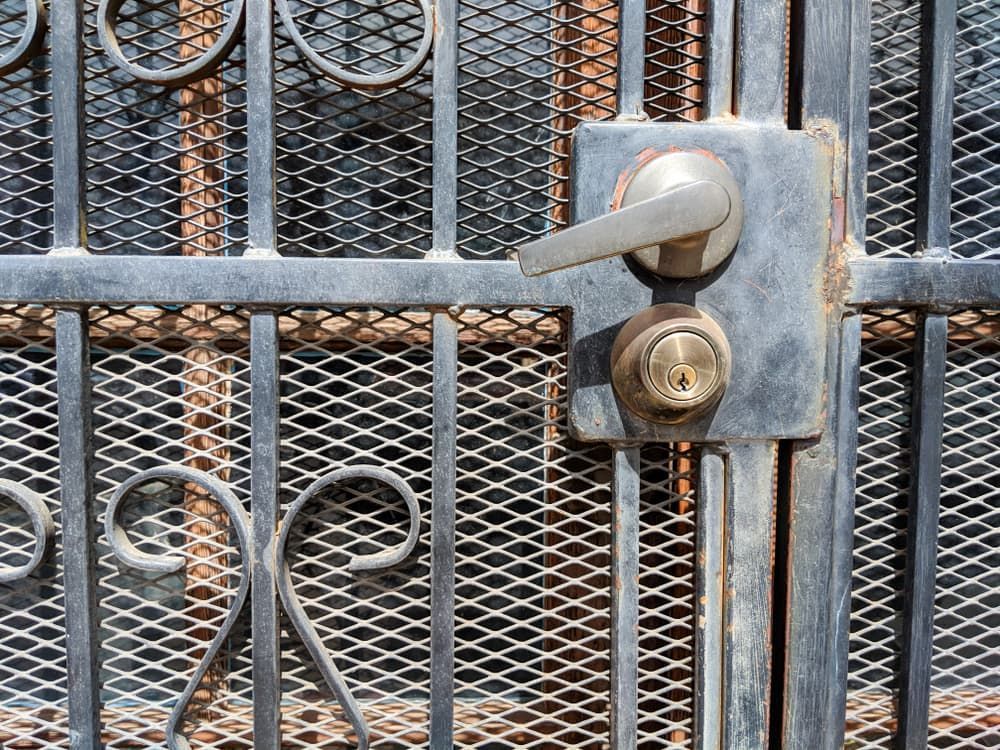 A Close Up Of A Rusty Wrought Iron Gate With A Door Handle — Summerland Screens & Awnings In Evans Head, NSW