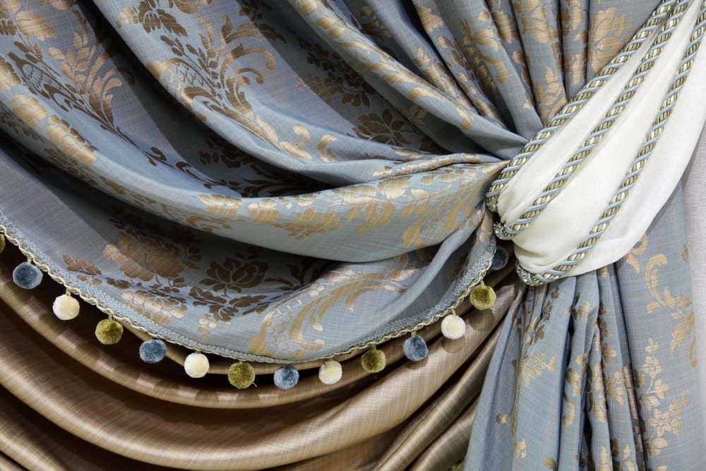 A Close Up Of A Blue And Brown Curtain With Pom Poms — Summerland Screens & Awnings In Alstonville, NSW