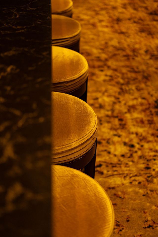 Stacked metal containers in warm yellow light beside a dark wall, viewed close up.