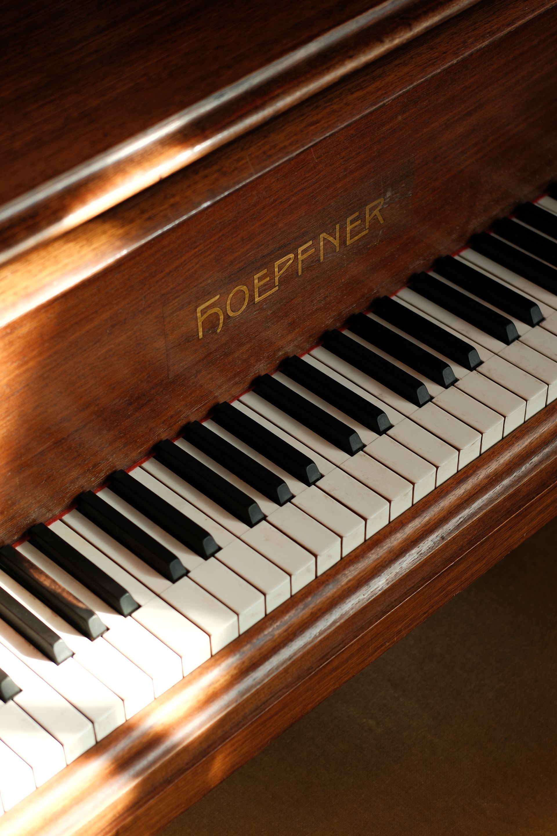 Close-up of a brown Hoffmann piano keyboard in warm sunlight