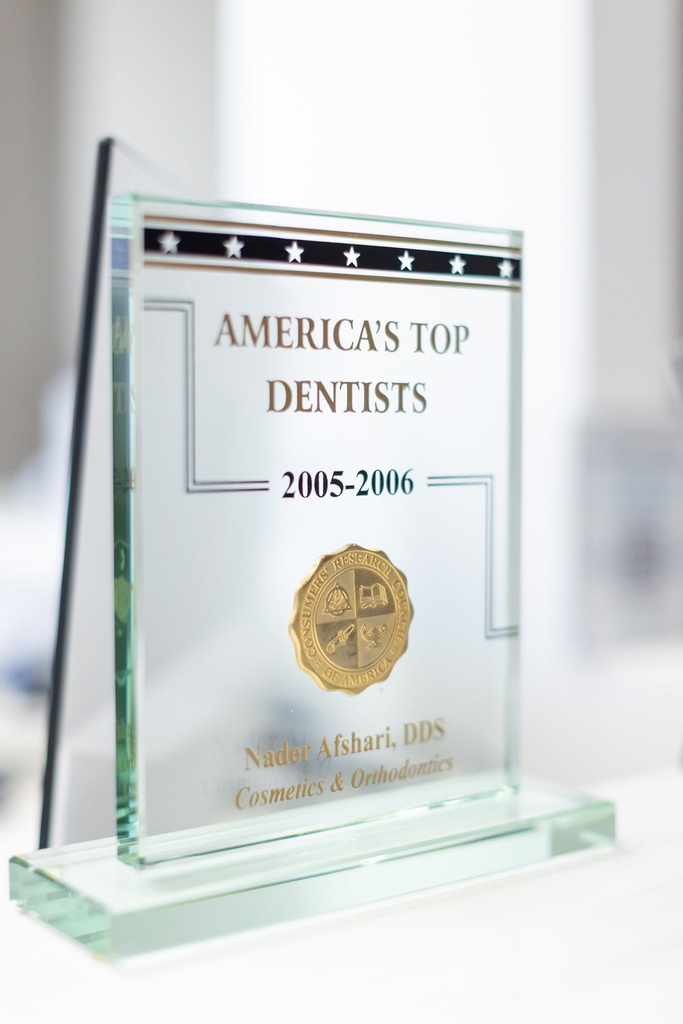 Glass award plaque for “America’s Top Dentists 2015–2016” on a white surface