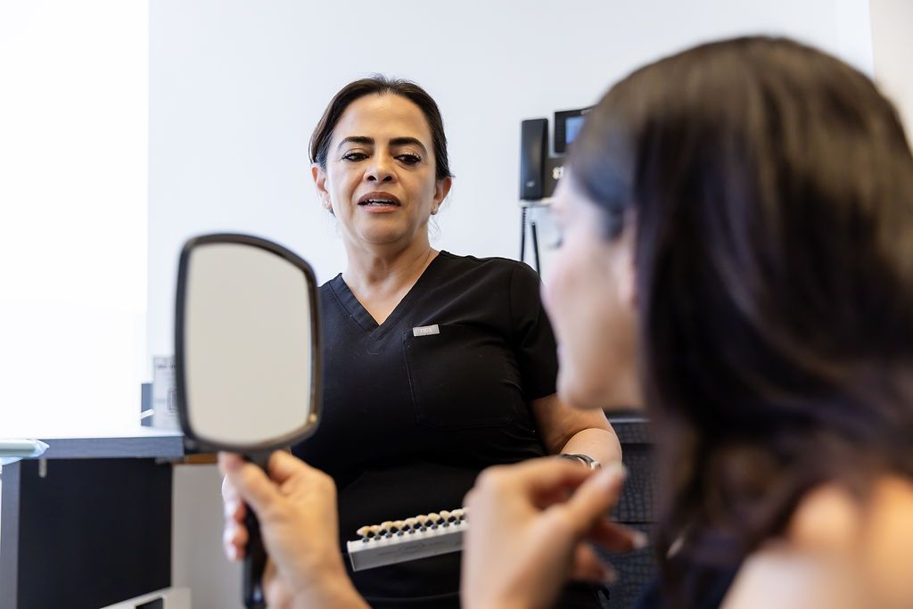 Woman in a clinic holding a mirror.