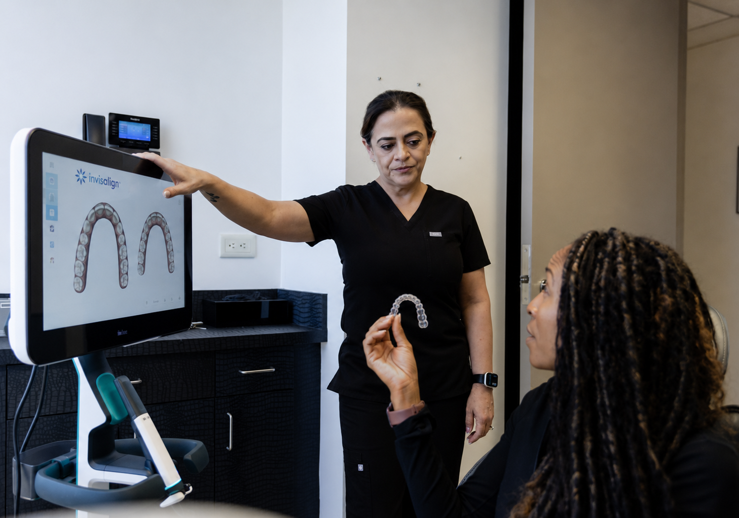 Clinician points to a dental scan on a monitor while speaking