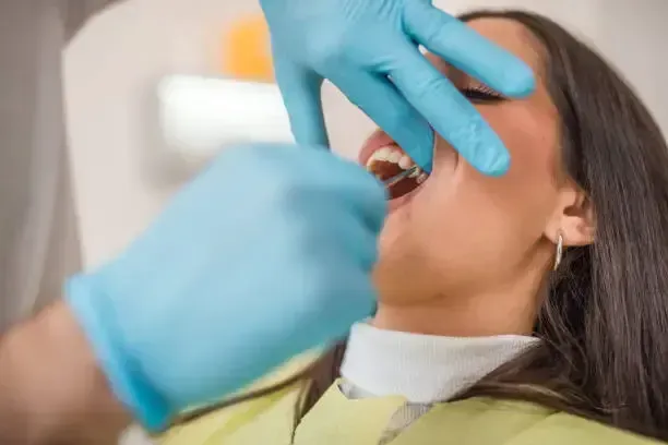 Dentist examining a smiling patient in a dental chair