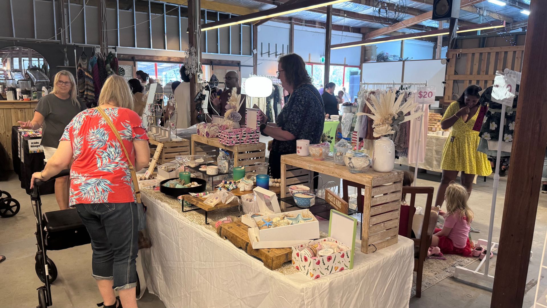 People browsing stalls at an indoor market, under a wooden roof — Rustique on the Coast In Ourimbah, NSW