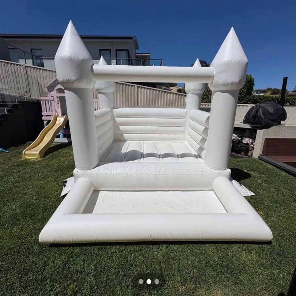 White inflatable bounce house in a backyard, with a slide visible — Rustique on the Coast In Ourimbah, NSW