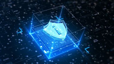 Glowing blue shield icon over a digital circuit grid, symbolizing cybersecurity protection