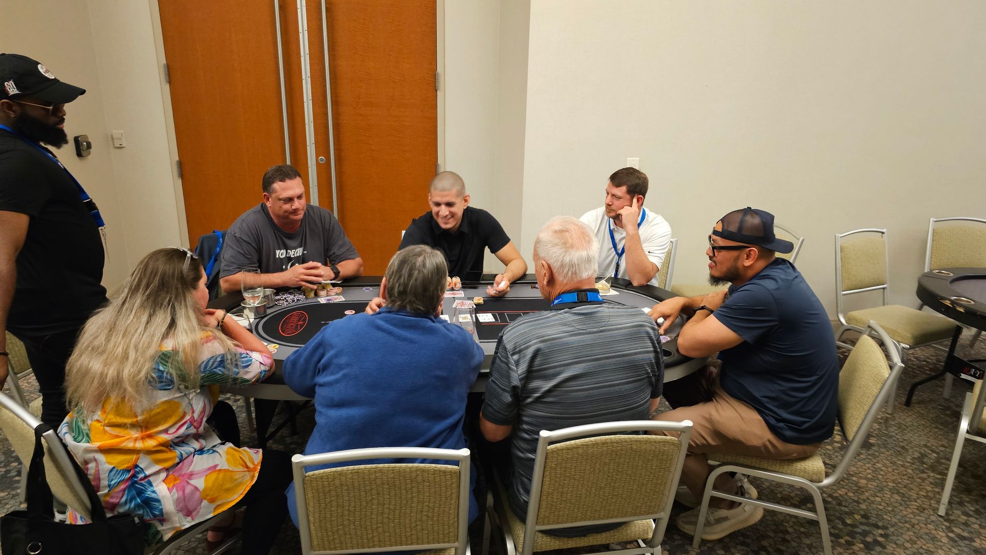 Small group in a conference room seated around a table in discussion, with papers and drinks on the table.