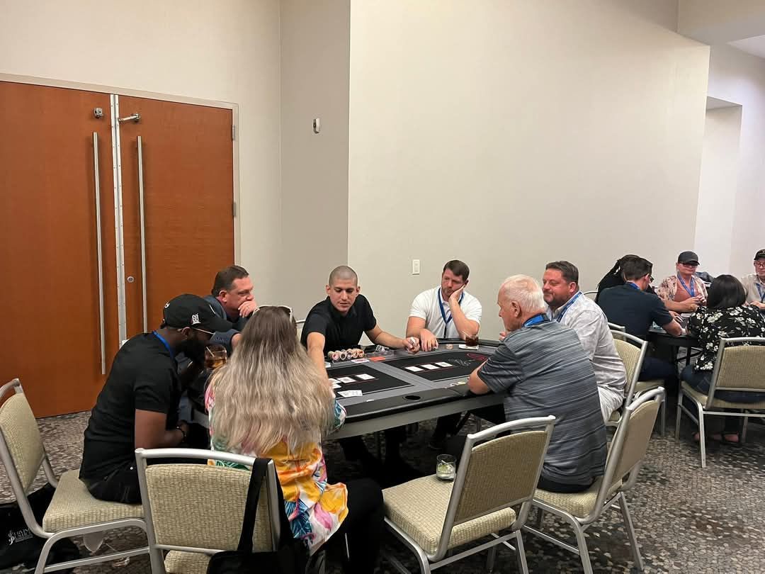 People seated around a table in a conference room, meeting and talking.