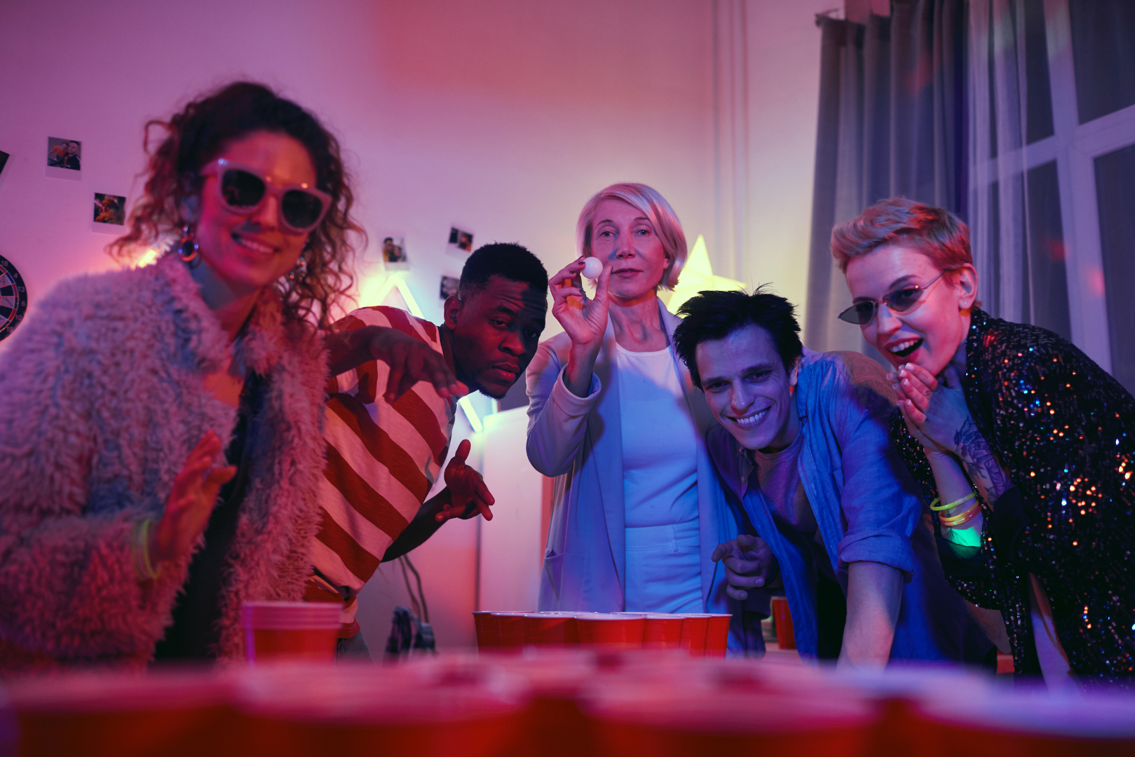 A group of young people are playing beer pong at a party.