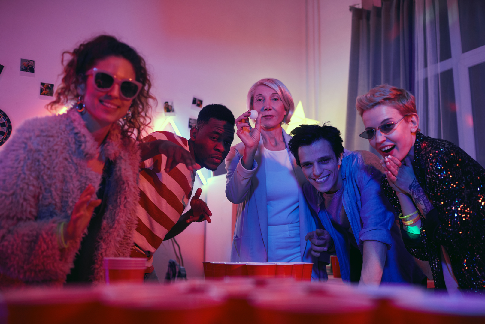 A group of people are playing beer pong at a party.