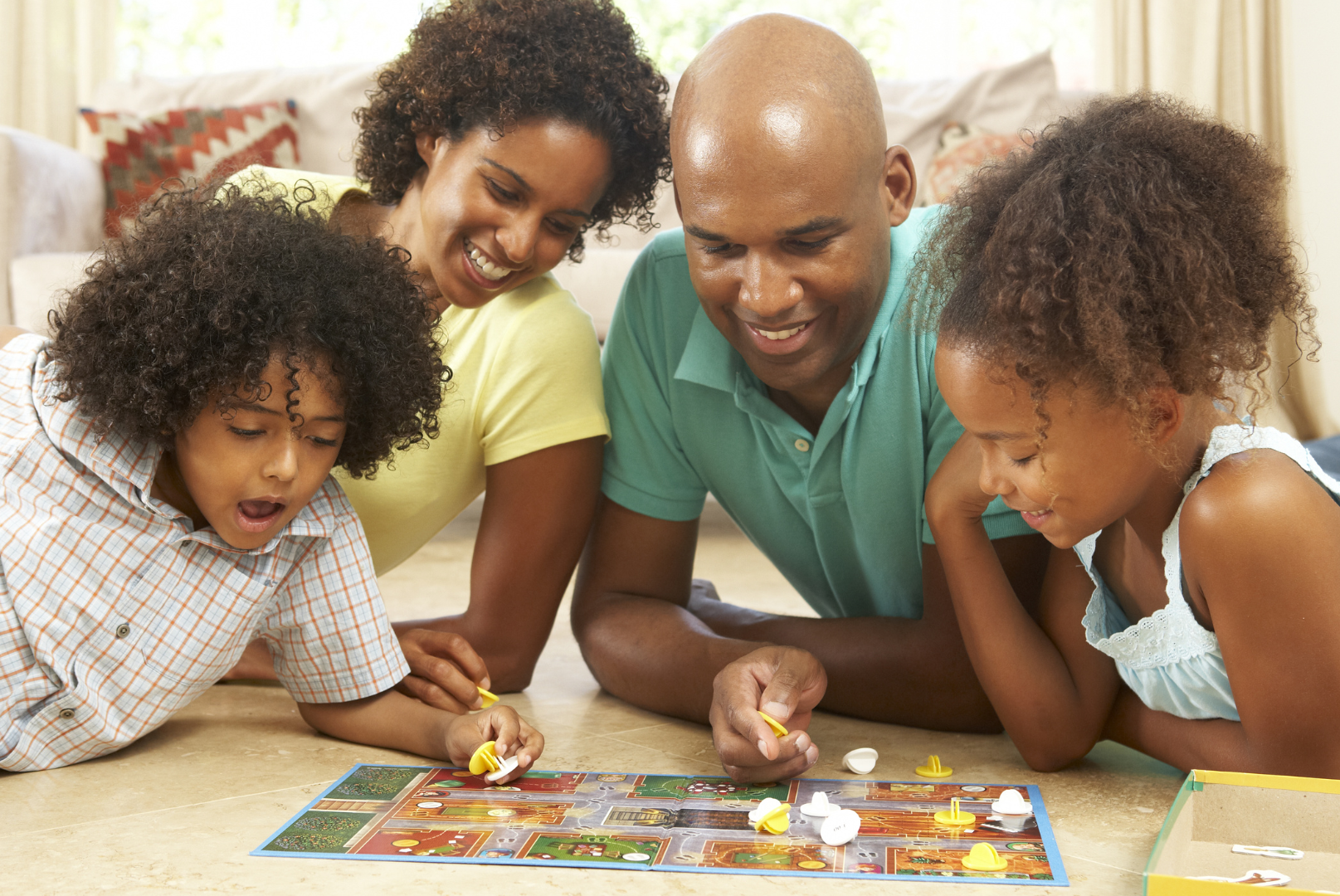 A family is playing a board game together on the floor.