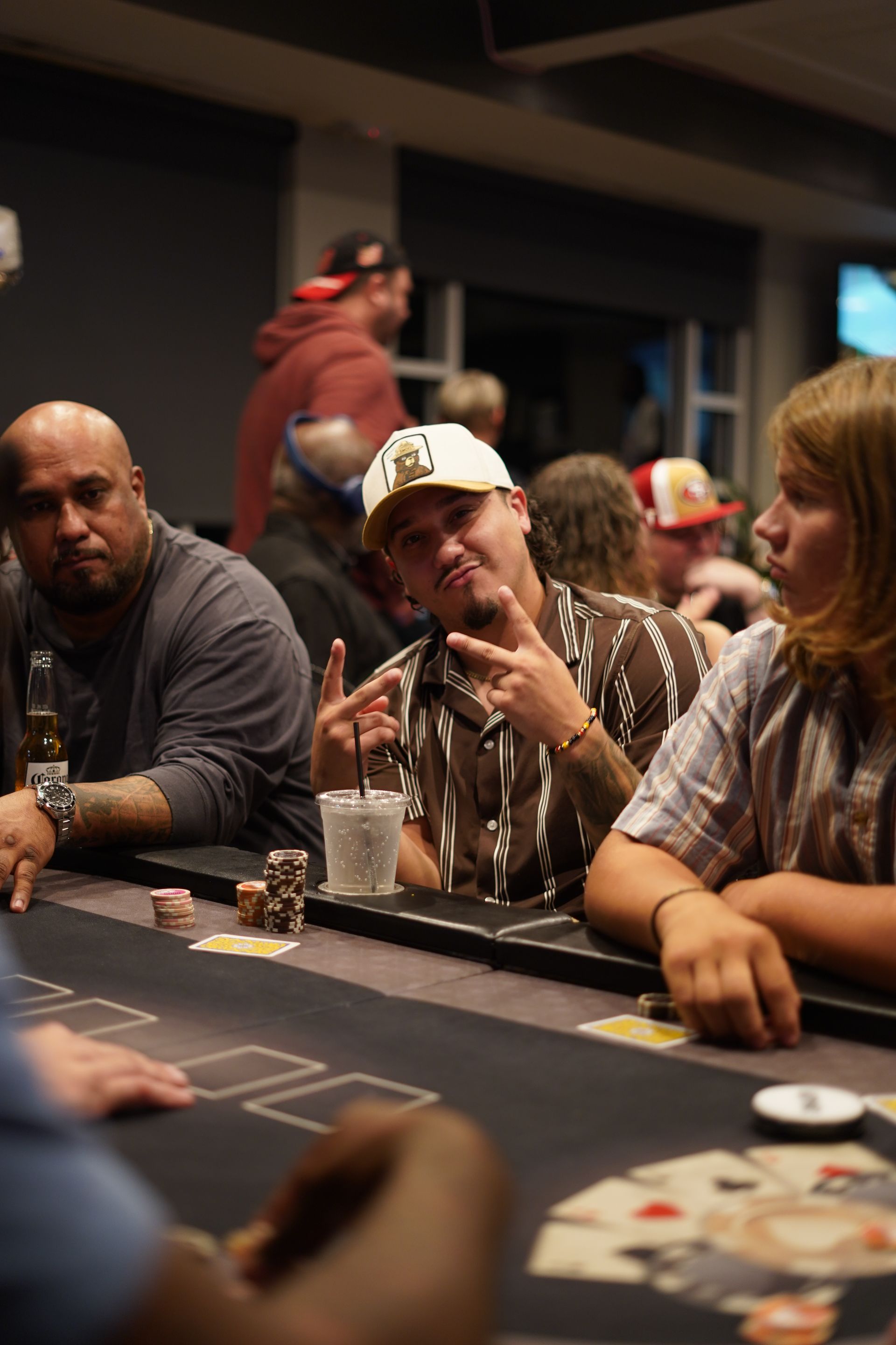 People playing poker at a casino table, with chips and cards visible in a dimly lit room