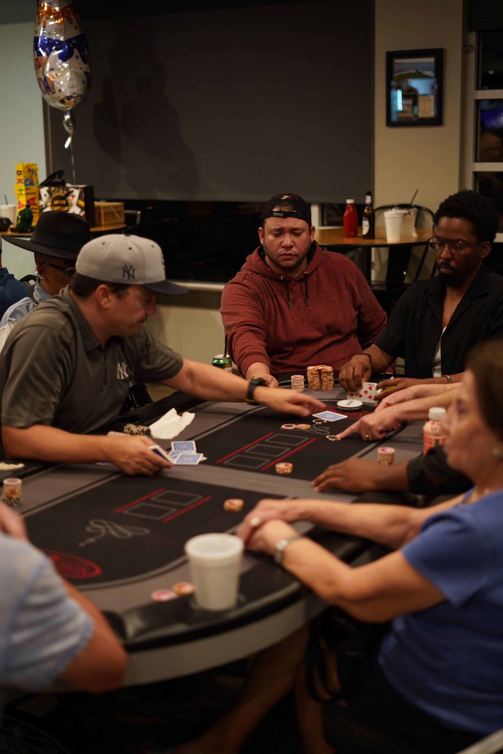 People playing cards at a casino table, focused on the game