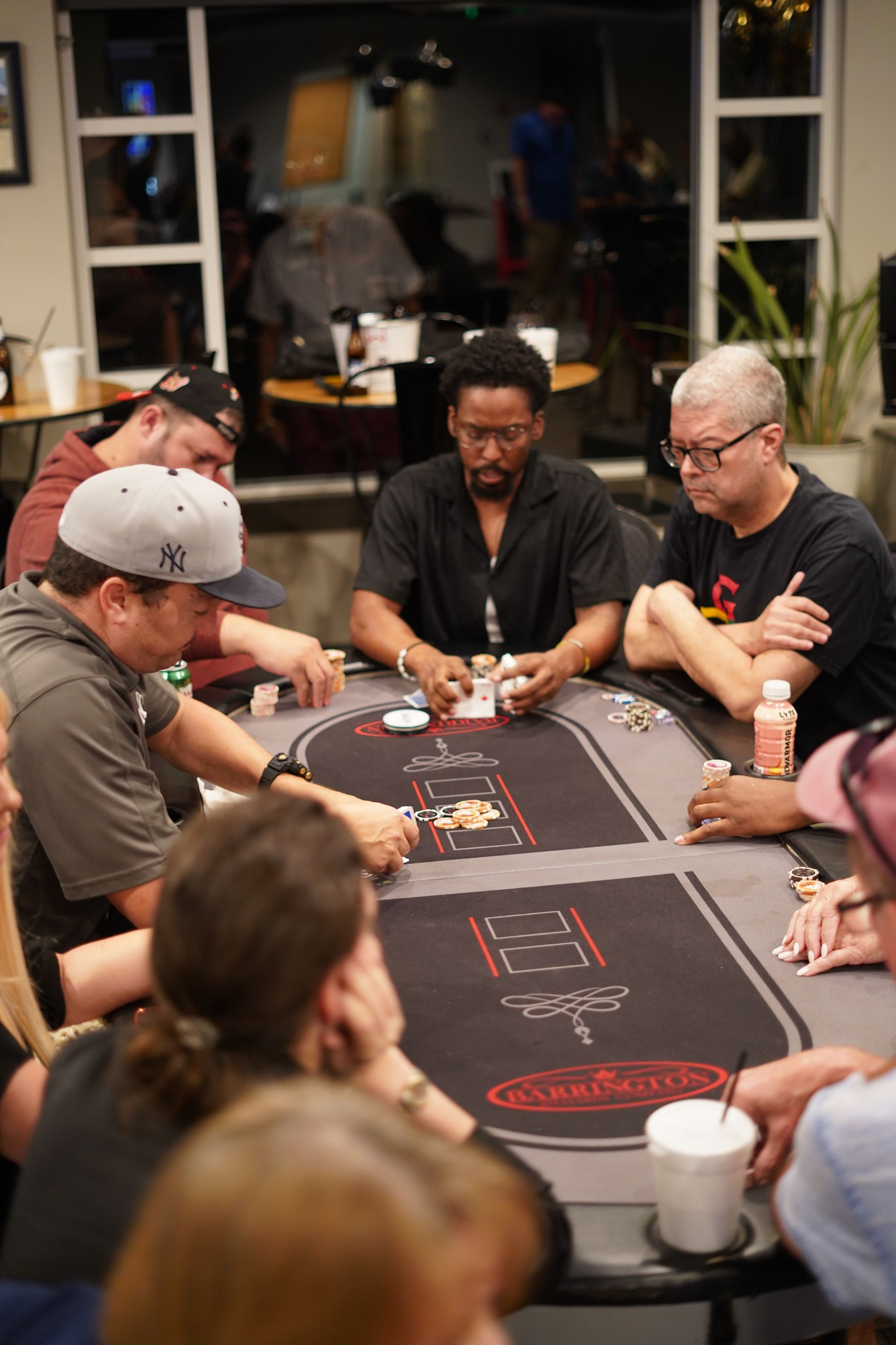 People playing poker around a table in a dimly lit room