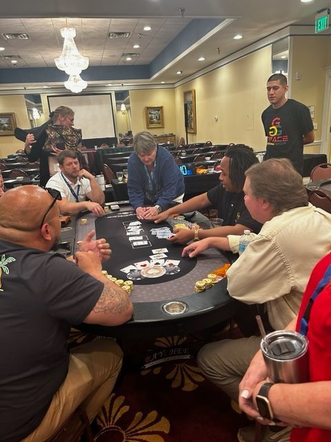 People playing cards around a round table in a casino lounge