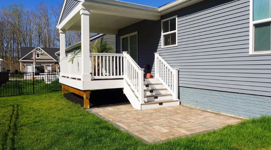 Residential deck with white railings and stone patio, built to Springfield code.