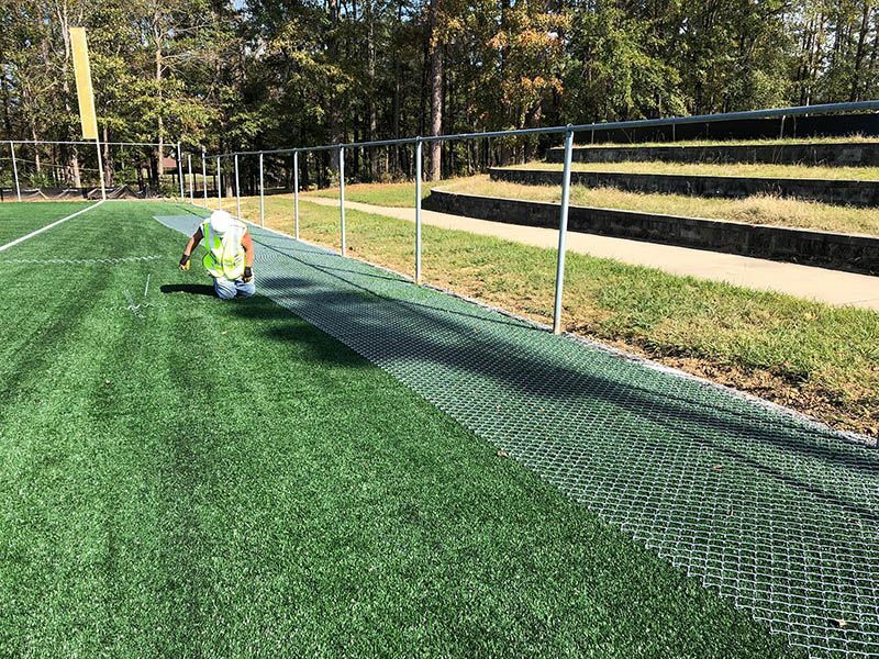 A person is standing on top of a soccer field.