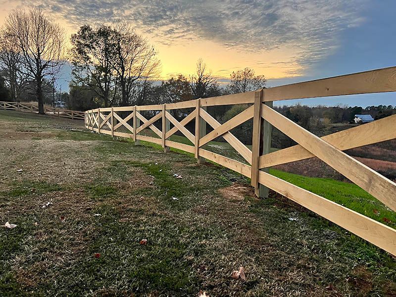 A wooden fence is sitting in the middle of a grassy field.