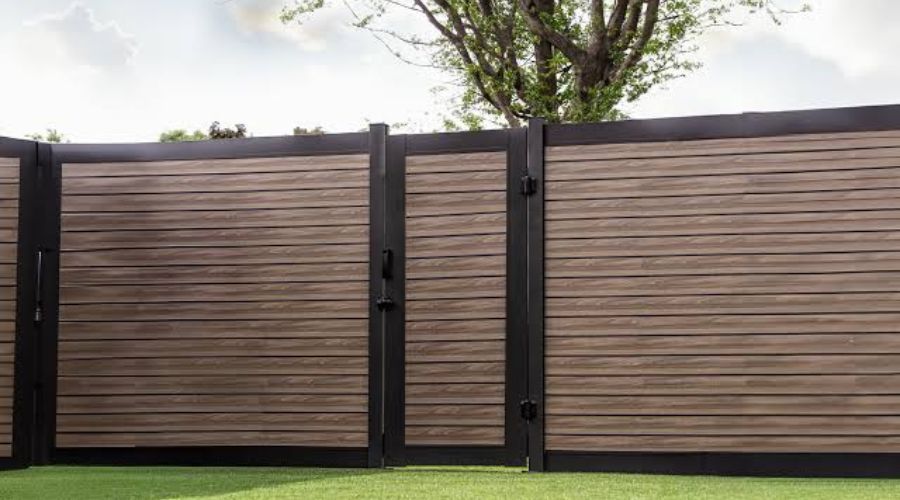 Brown horizontal composite privacy fence with a sagging walk gate in the Ozarks.