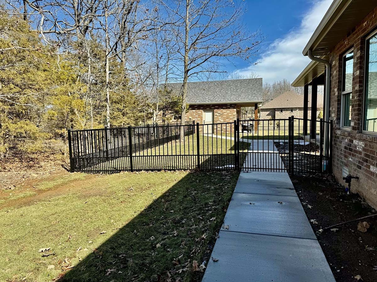 A house with a fence and a walkway leading to it.