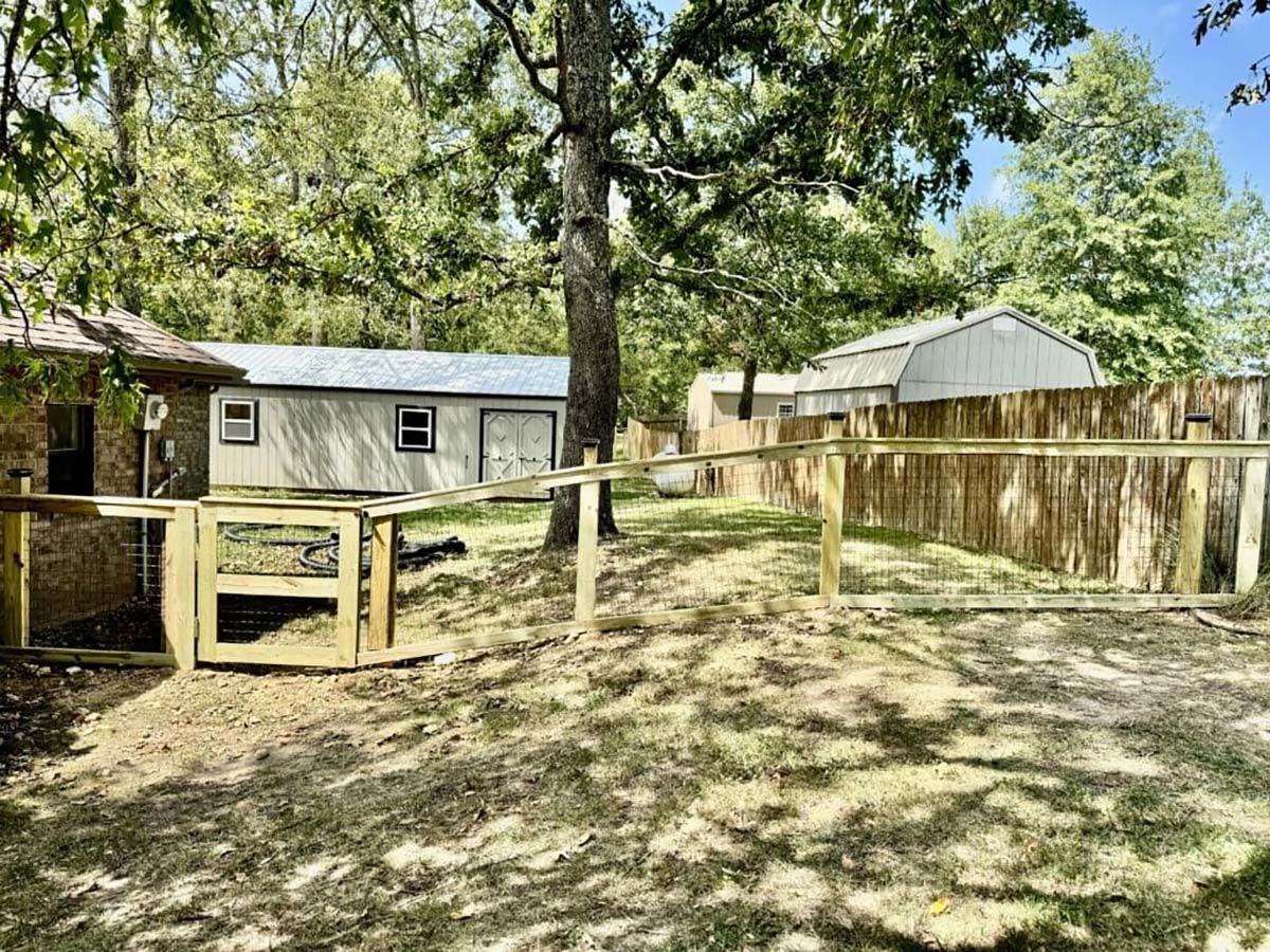 There is a wooden fence in the backyard of a house.