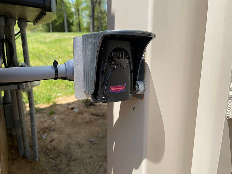 A close up of a security camera mounted on a pole.