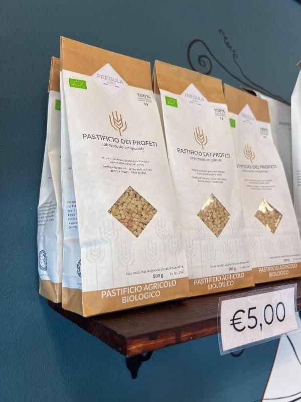 Tre confezioni di pasta sono su uno scaffale con un cartellino del prezzo di 5,00