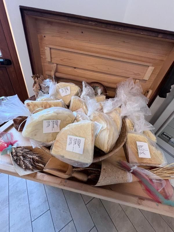 Una scatola di legno piena di formaggi di vario tipo.