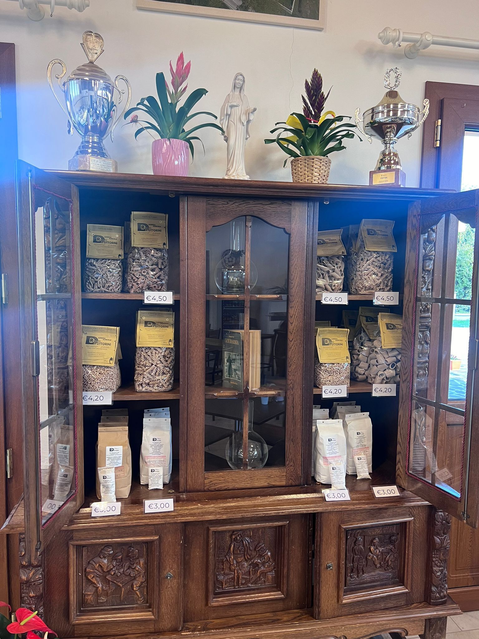 Una credenza di legno piena di cibo e trofei.