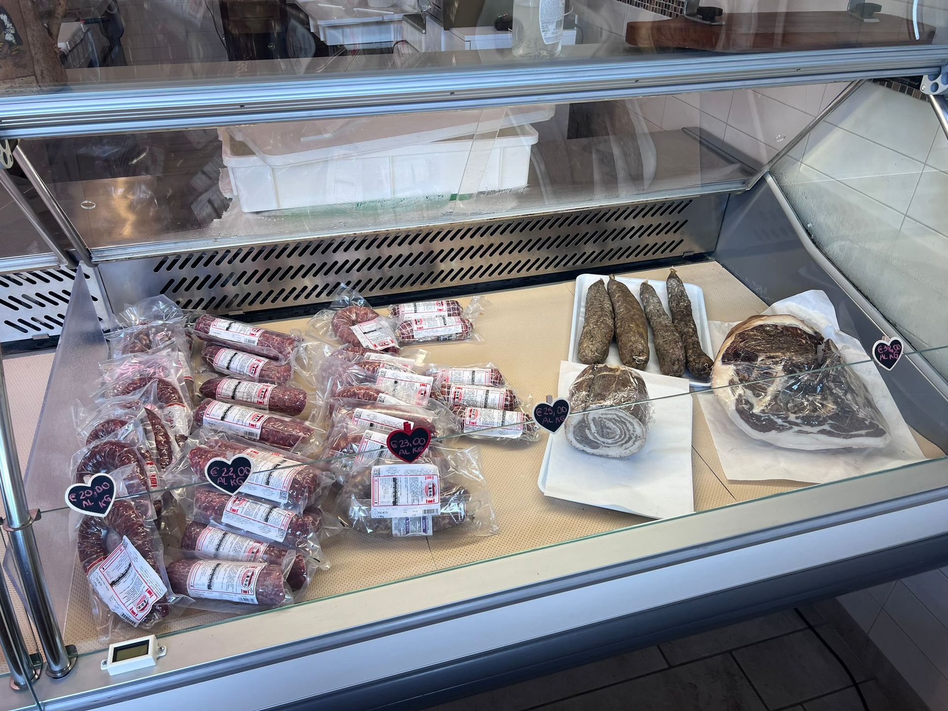 Una vetrina piena di vari tipi di carne e pane.