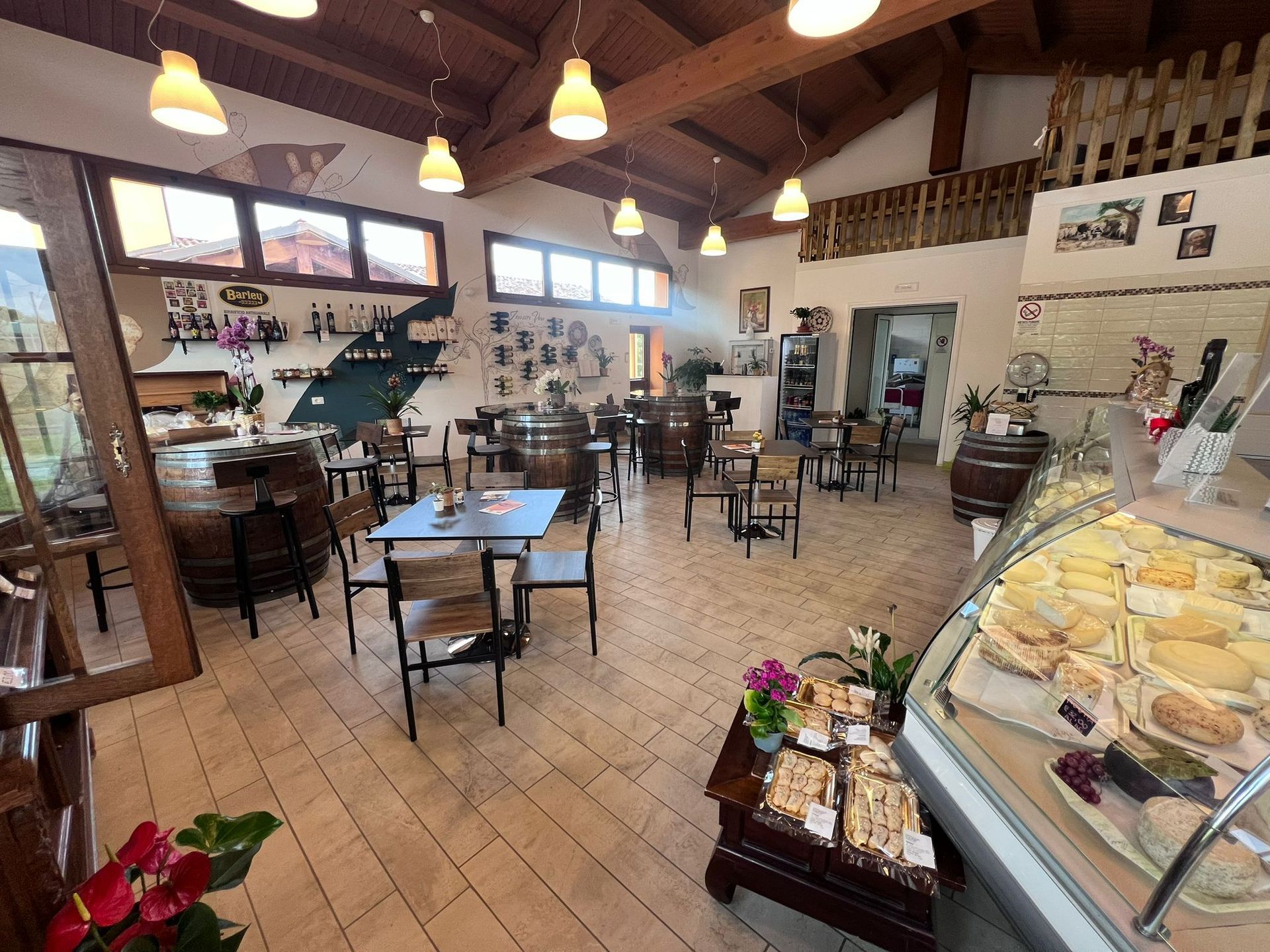 Un ristorante con tavoli e sedie e una vetrina di cibo.