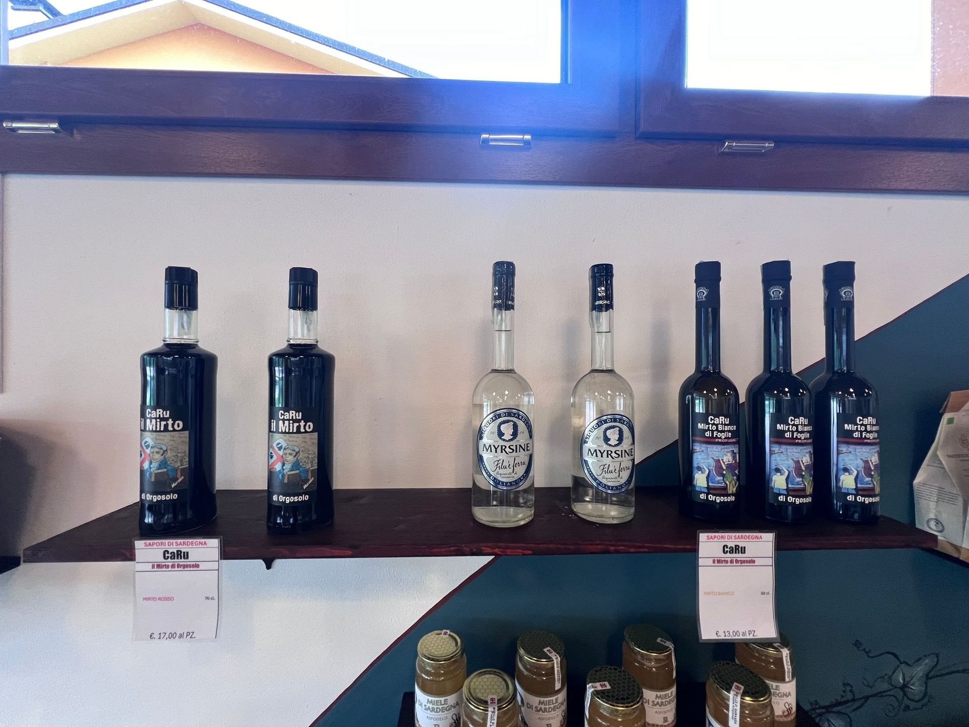Diverse bottiglie di liquore sono allineate su uno scaffale