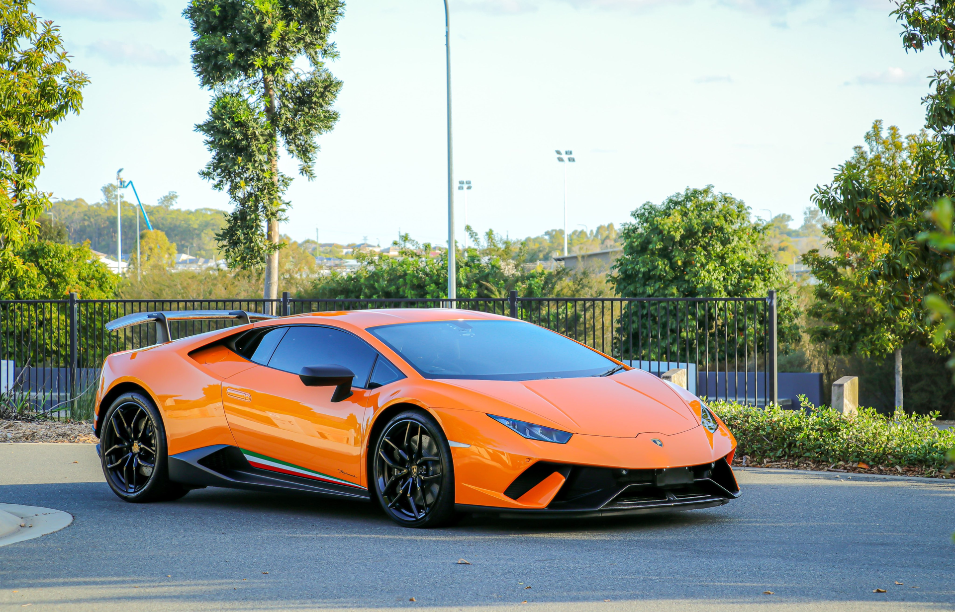 Orange Lamborghini sports car parked on a road.