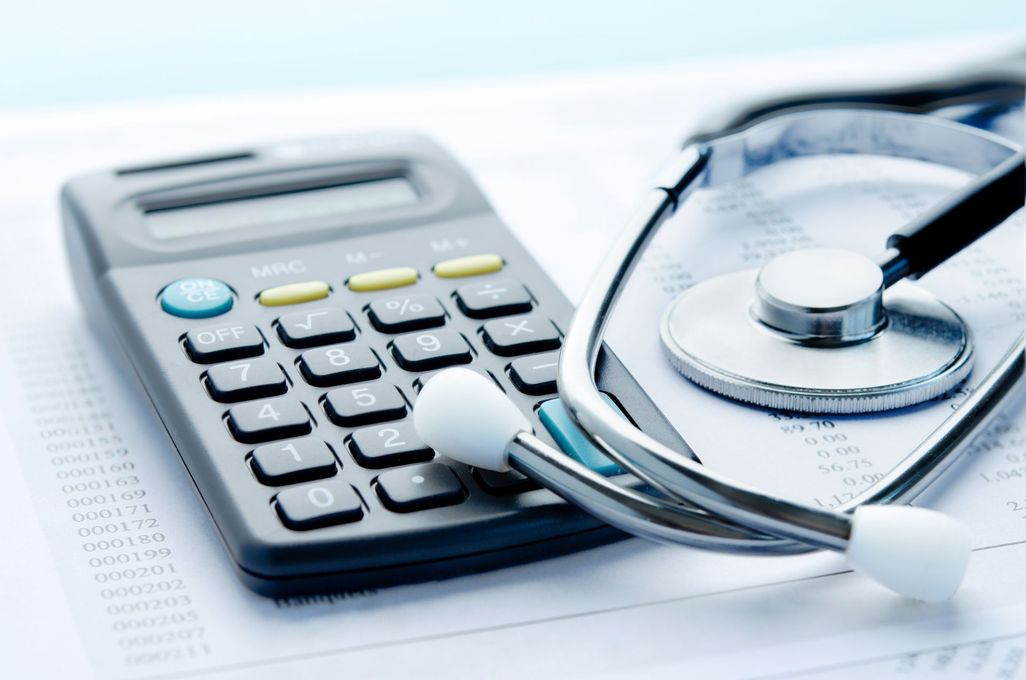 Calculator and stethoscope on a desk, suggesting medical billing or healthcare finance.