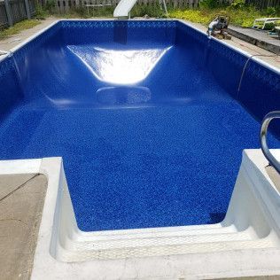 Blue-lined swimming pool with steps, viewed from the shallow end.  