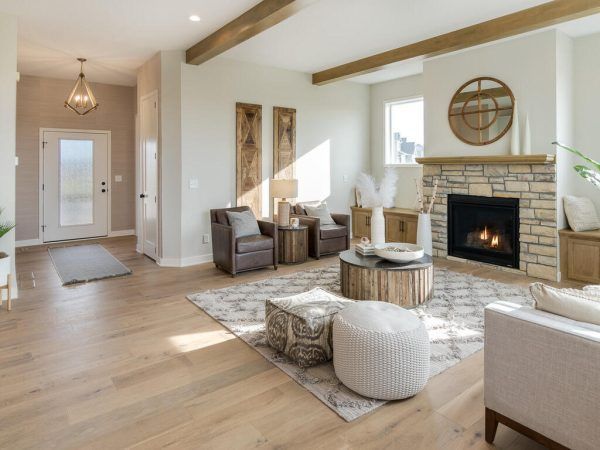 Living room with fireplace, light wood floors, neutral tones, and decorative accents.