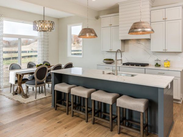 Modern kitchen with island seating, dining table, and natural light.