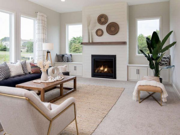 Living room with fireplace, sofa, and decorative accents in neutral tones.