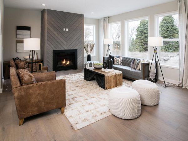 Living room with fireplace, brown leather chair, gray sofa, and wooden coffee table.