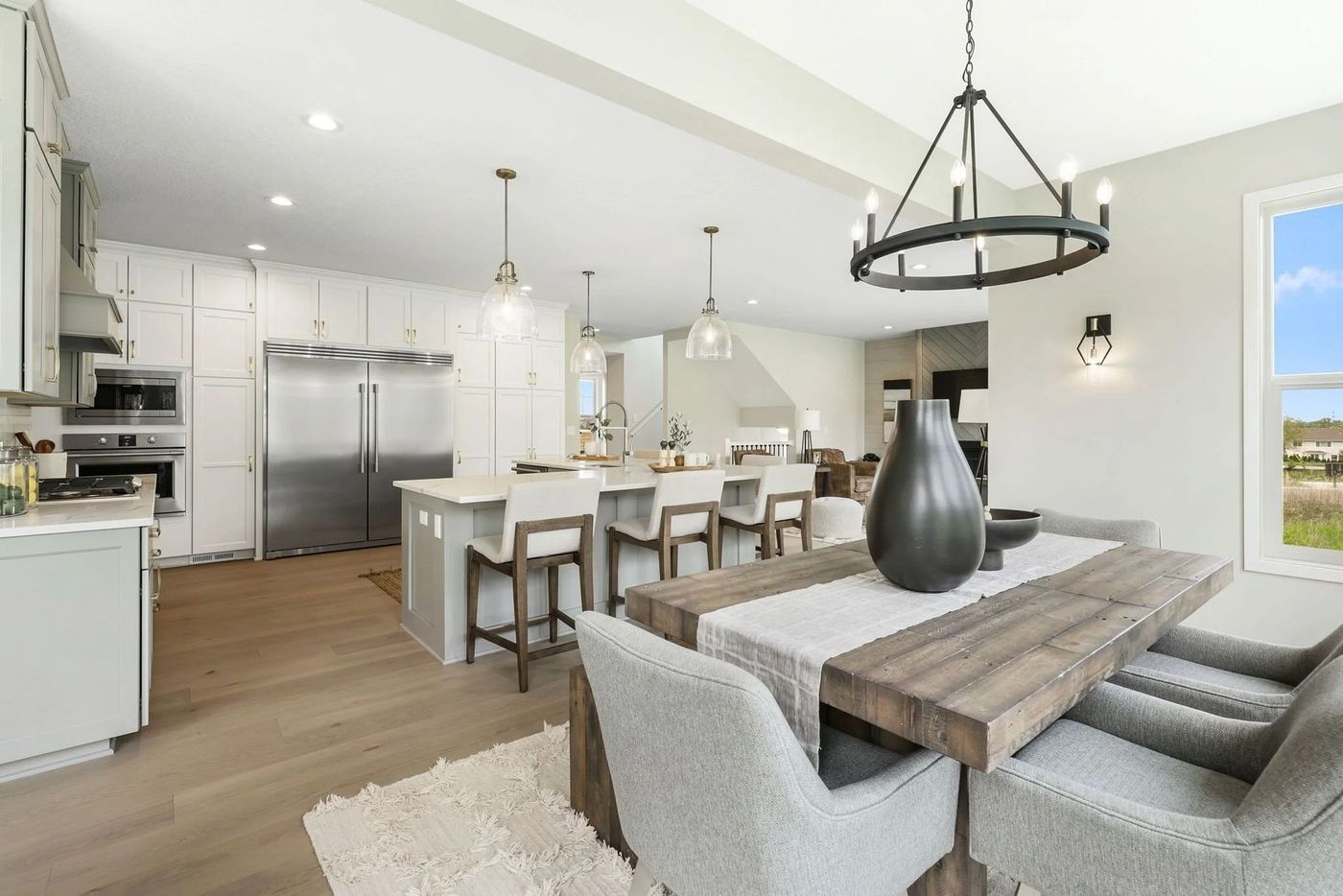 Modern kitchen and dining area with gray and light wood tones.