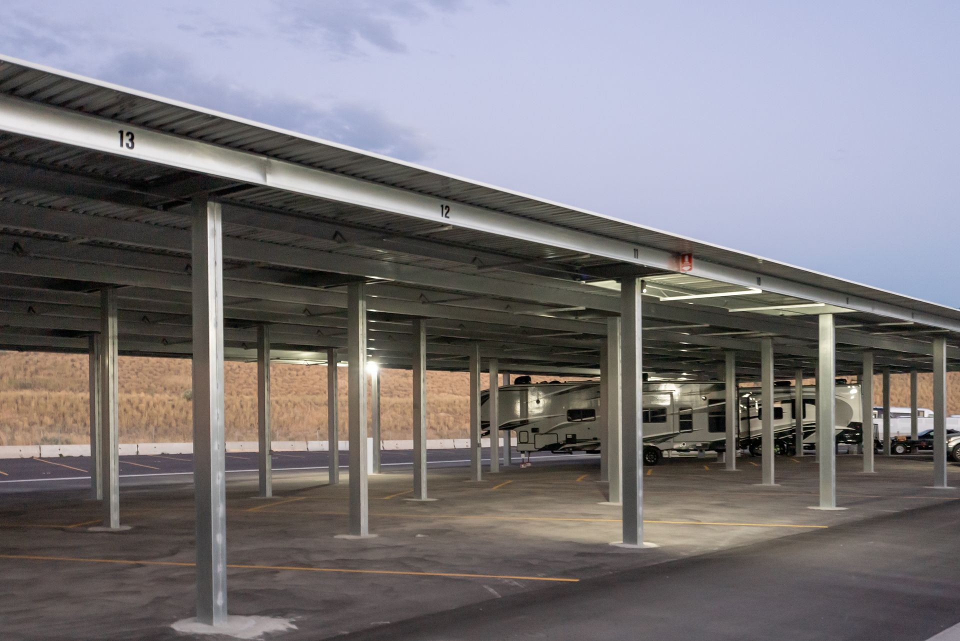 A parking lot with a lot of cars parked under a roof.