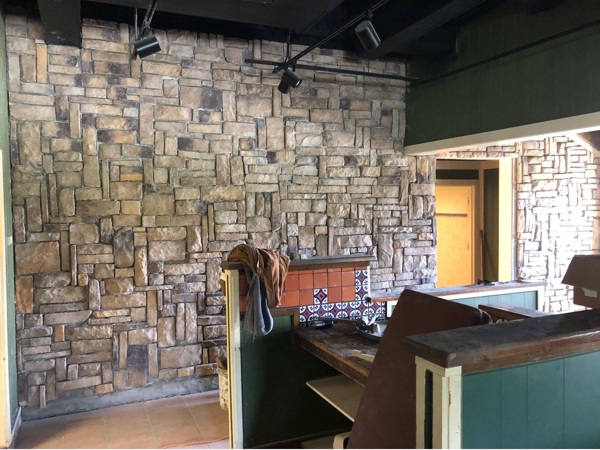 A room with a stone wall and a table in front of it