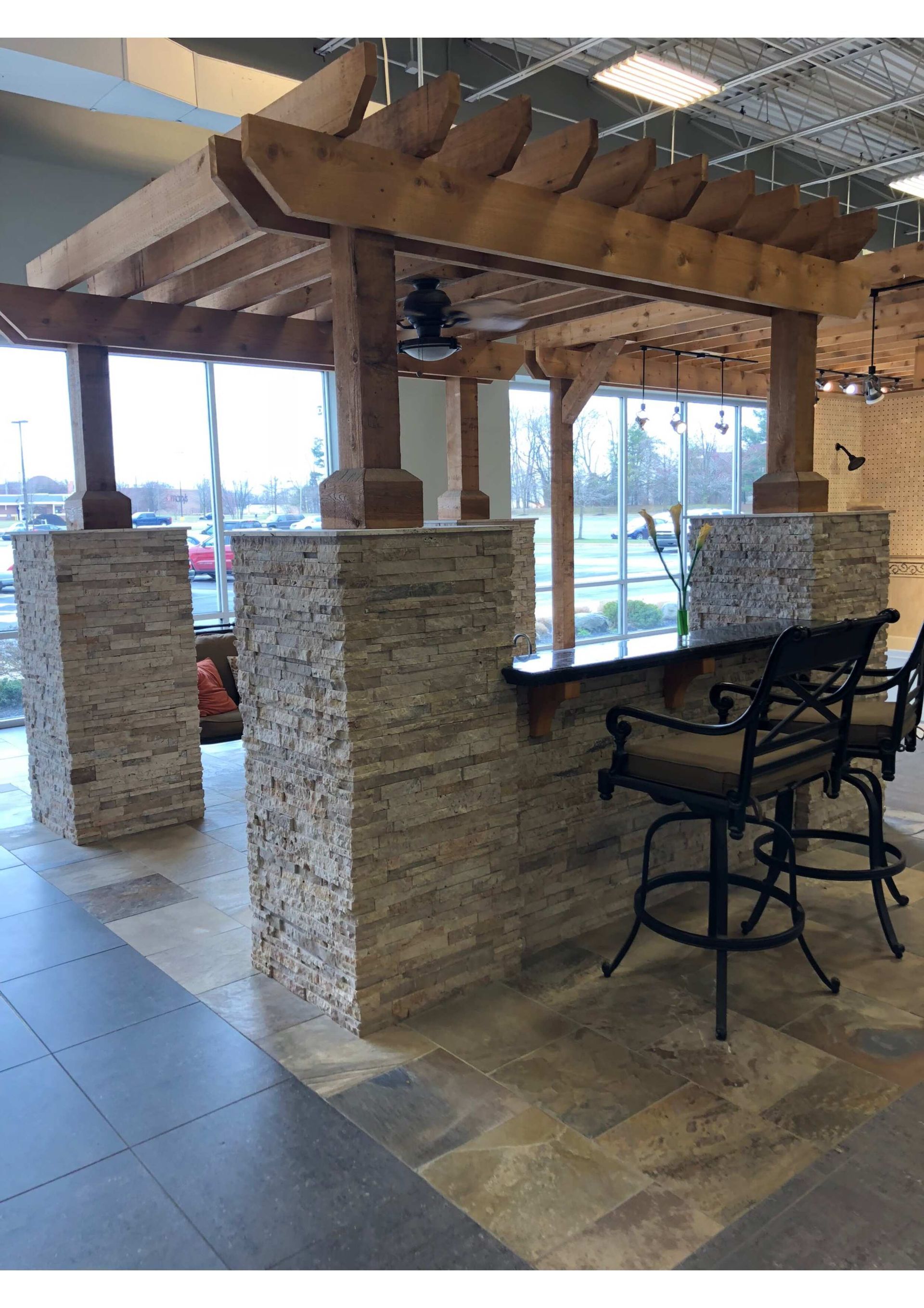 A bar with a pergola and a ceiling fan
