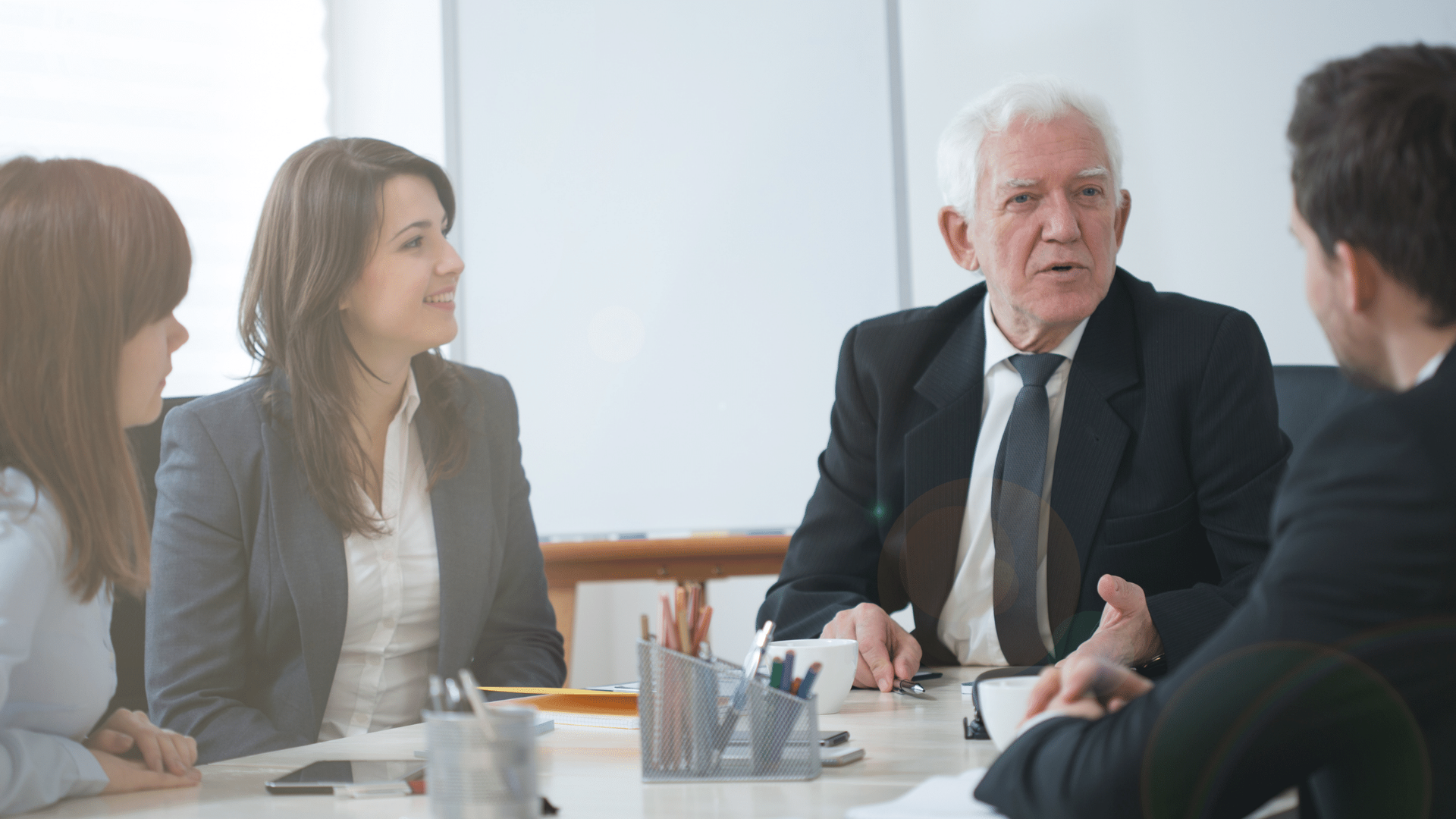 A group of people are sitting around a table having a meeting.