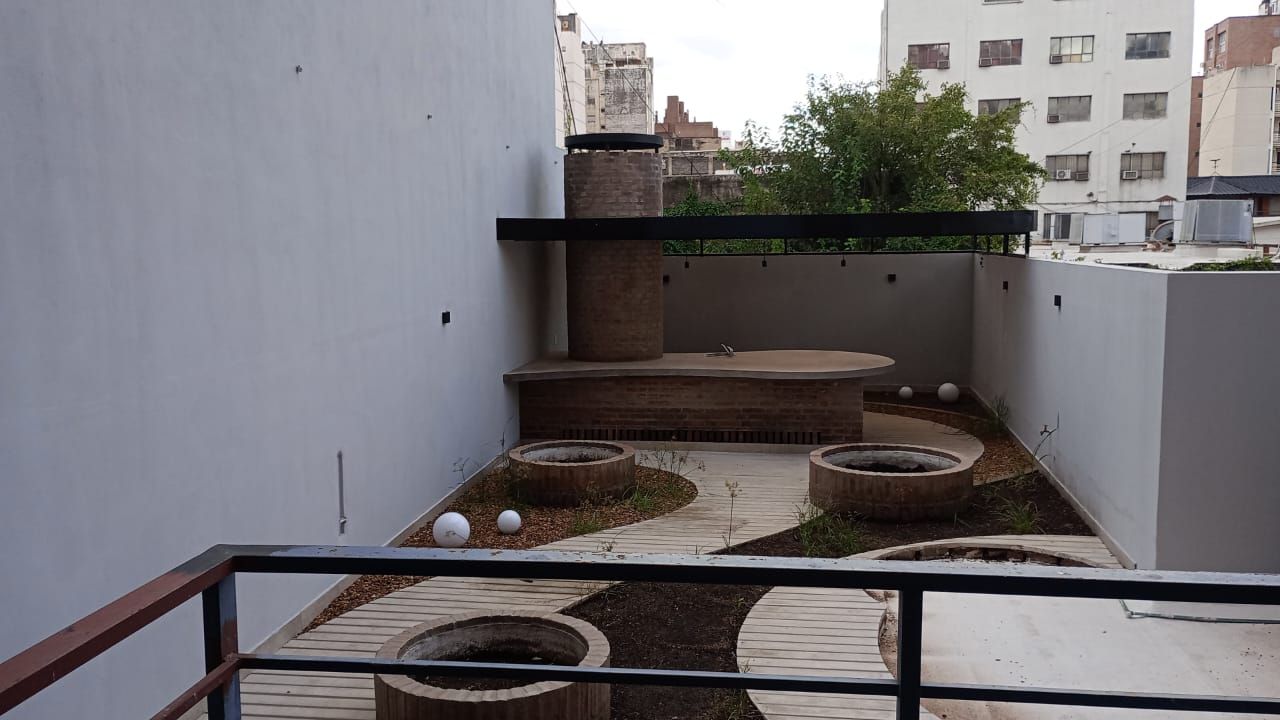 Modelo de un parque urbano moderno con césped, árboles y senderos para caminar, rodeado de altos rascacielos.
