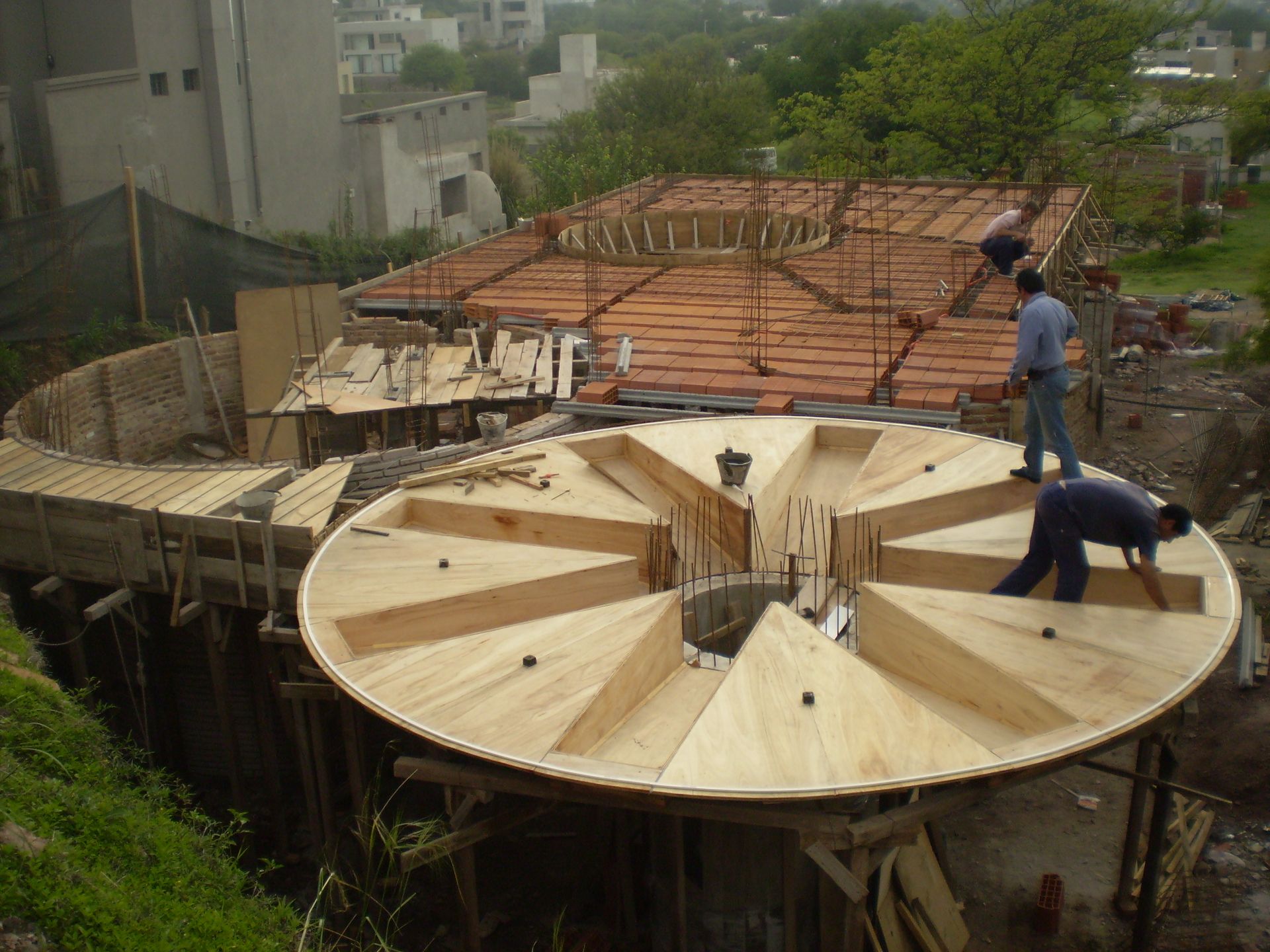 Un equipo de construcción revisa los planos en una obra, con cascos y chalecos de seguridad.