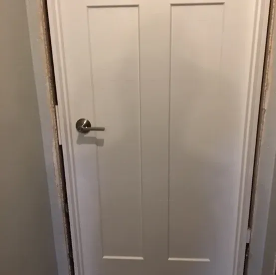 White interior double door with a silver lever handle on the left panel.