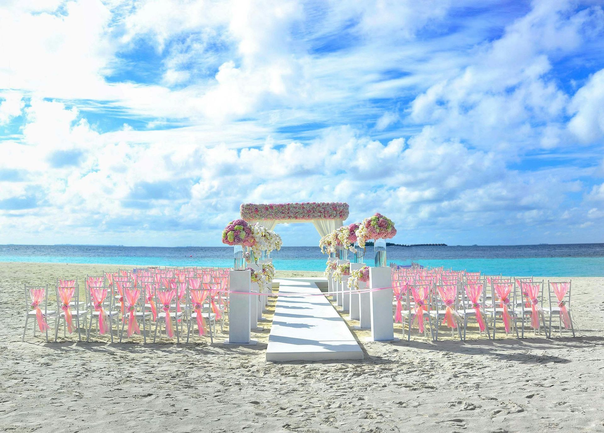 A wedding ceremony is taking place on a tropical beach.